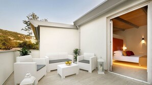 A balcony with white wicker furniture, a small table with fruit, and a lantern. - Da Rooms (Sorrento)