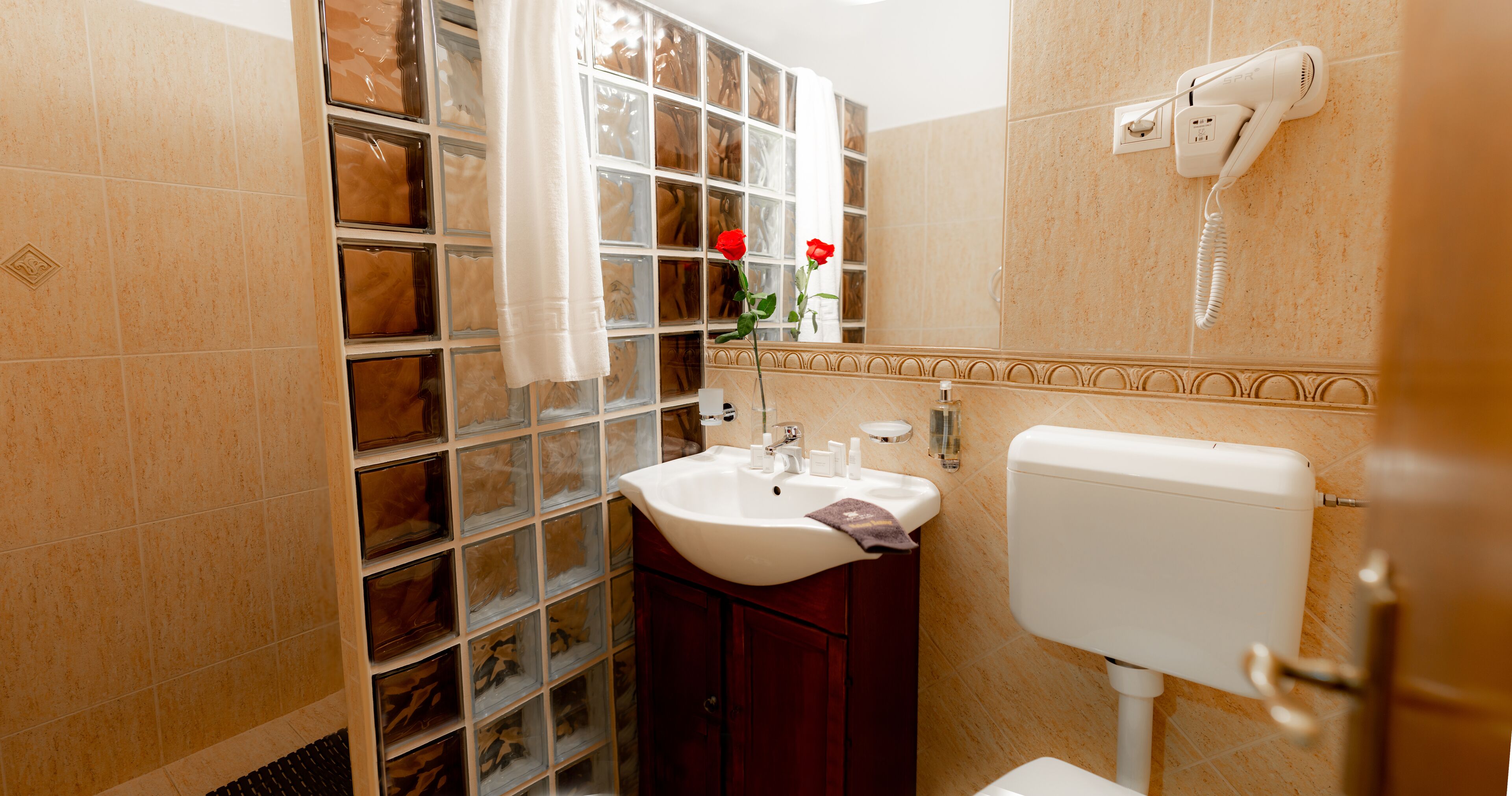 Un baño con cabina de ducha de vidrio, un lavabo blanco y un inodoro.