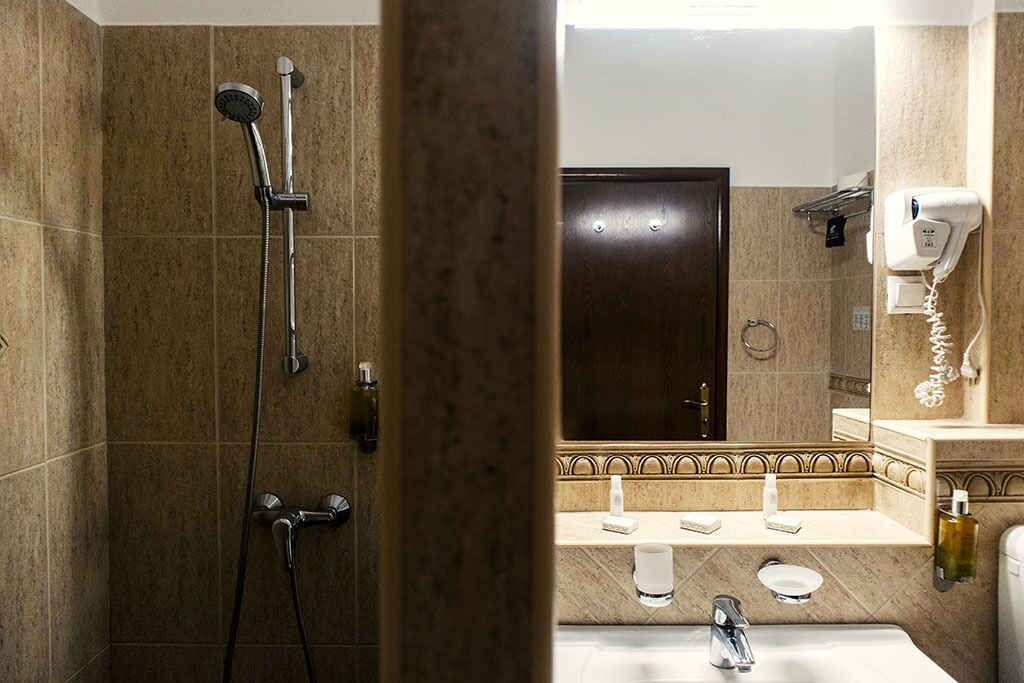 A bathroom with a shower, sink, and a mirror.