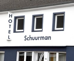 A hotel named 'Schuurman' with three windows and a sign indicating the number 10.