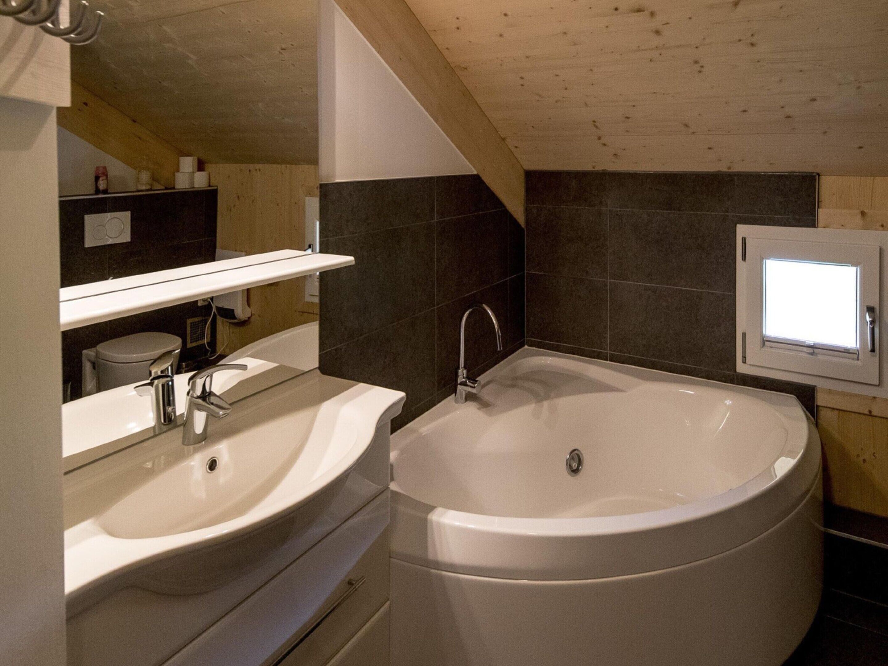 A modern bathroom with a freestanding bathtub, a vanity with a sink, and a mirror.