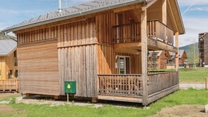 Een houten gebouw met een balkon en schoorsteen.