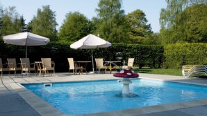 A swimming pool with lounge chairs and umbrellas. - Chalet Near Campground (De Bult)