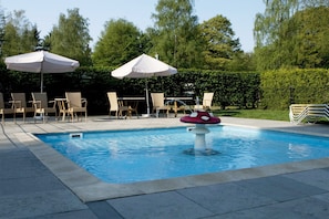 Piscina com espreguiçadeiras e guarda-sóis.
