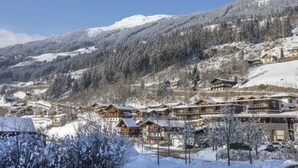 A snow-covered mountain village with wooden buildings and a clear blue sky. - Spacious Stay With Mountain View (Wald im Pinzgau)