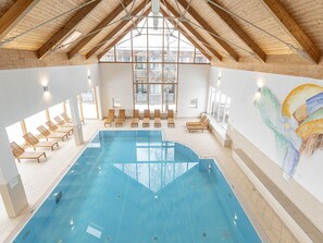 An indoor swimming pool with wooden beams and large windows. - Holiday Home on the Kresichberg With Swimming Pool (Sankt Georgen am Kreischberg)