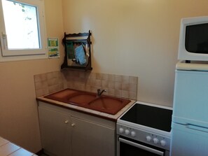 A kitchen with a sink, stove, and cabinets. - Holiday Home in Quend-plage Near Forest (Quend)