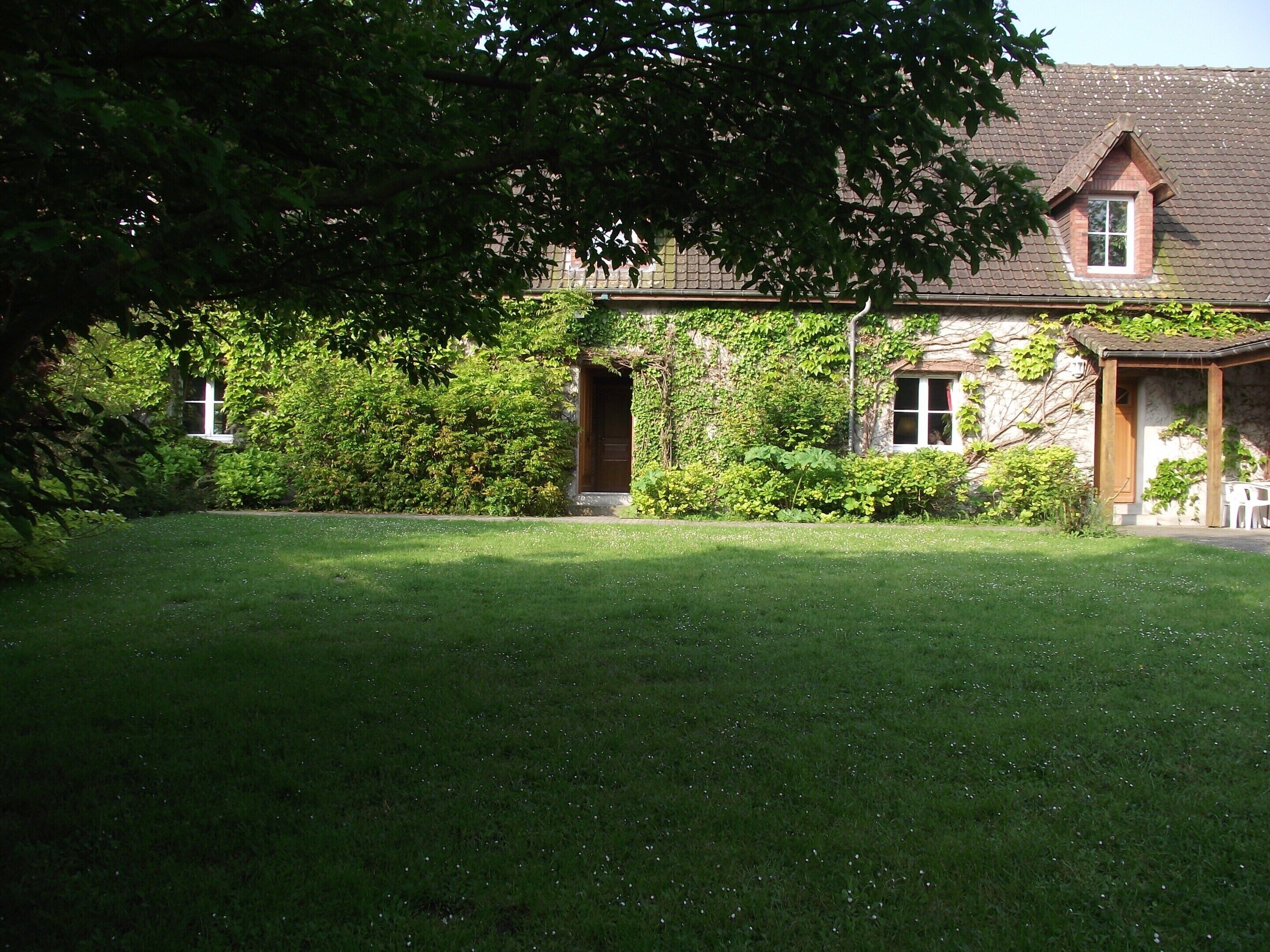 A house with a well-maintained lawn, a wooden door, and a window.