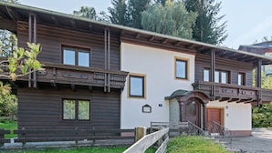 Een gebouw met twee verdiepingen, een houten gevel en een balkon.