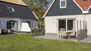A residential property with a large patio area, a dining set, and a covered outdoor seating area.