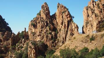 A rugged mountain landscape with rocky cliffs and sparse vegetation.