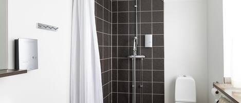 A modern bathroom with a shower, toilet, and bathtub.
