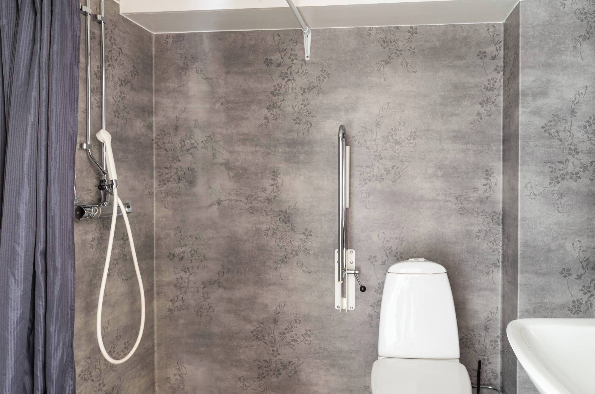 A modern bathroom with a shower, toilet, and sink.