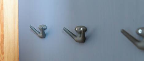 Three metal hooks on a wall.