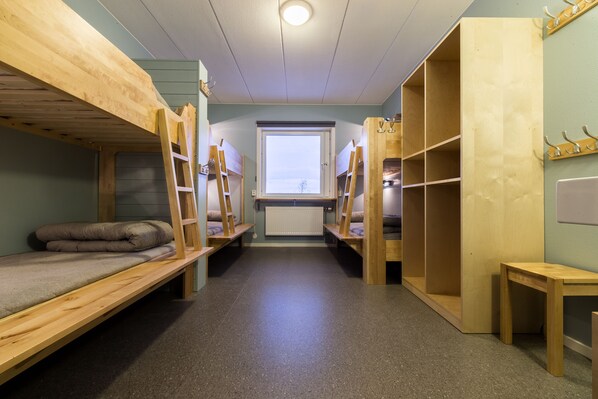 Un dormitorio con literas, una ventana y un radiador.