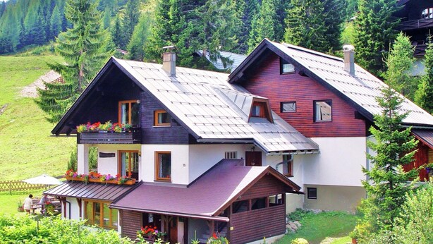 A two-story house with a sloped roof, a balcony with flower boxes, and a visible number '70' on the side. - Summer Vacation at Nassfeld (Hermagor-Pressegger See)