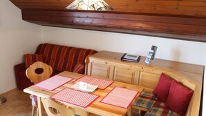 A cozy room with a wooden table, a bench, and a sofa. - Summer Vacation at Nassfeld (Hermagor-Pressegger See)