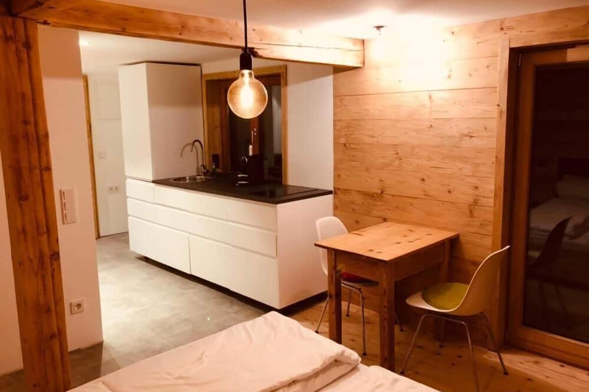 Un dormitorio pequeño con cama, un escritorio y una silla.