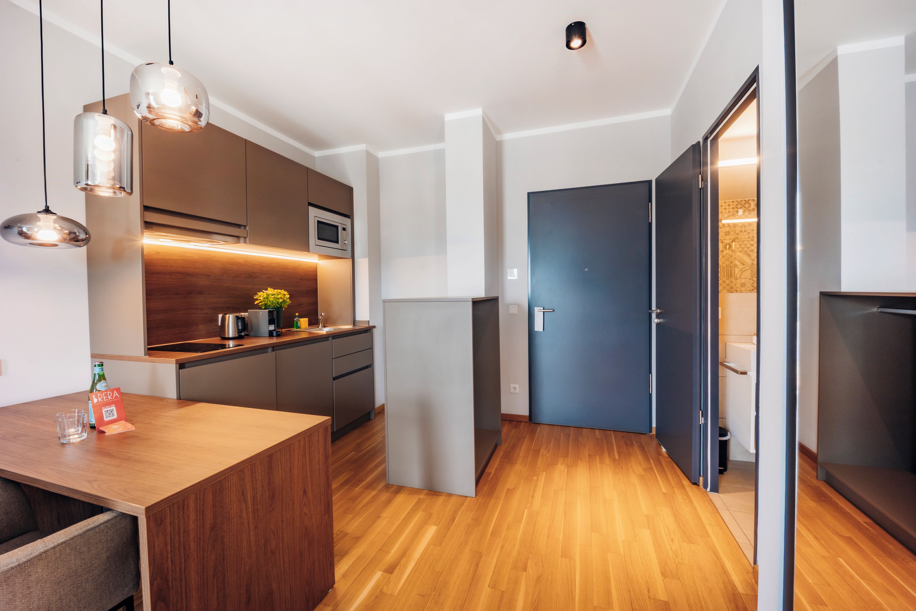 Una cocina moderna con armarios de madera, un microondas y un horno empotrado.