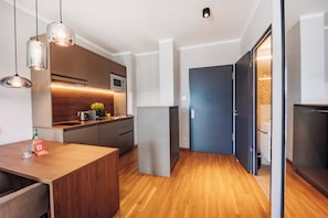 Une cuisine moderne avec des meubles en bois, un four à micro-ondes et un four encastré.