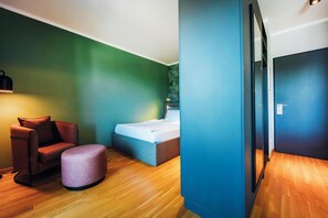 A modern bedroom with a bed, a chair, and a small table.