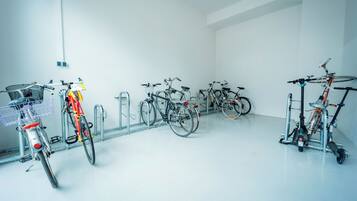 Una habitación limpia y blanca con varias bicicletas estacionadas junto a la pared.