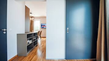 A modern interior with a sliding door, a desk with a chair, and a television on the wall.