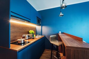 A compact kitchen with a wooden countertop, a built-in microwave, and a stainless steel kettle. - Brera Serviced Apartments Ulm (Ulm)