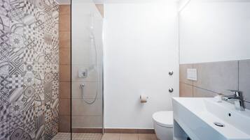 Ein Badezimmer mit Dusche, Toilette und Waschbecken.