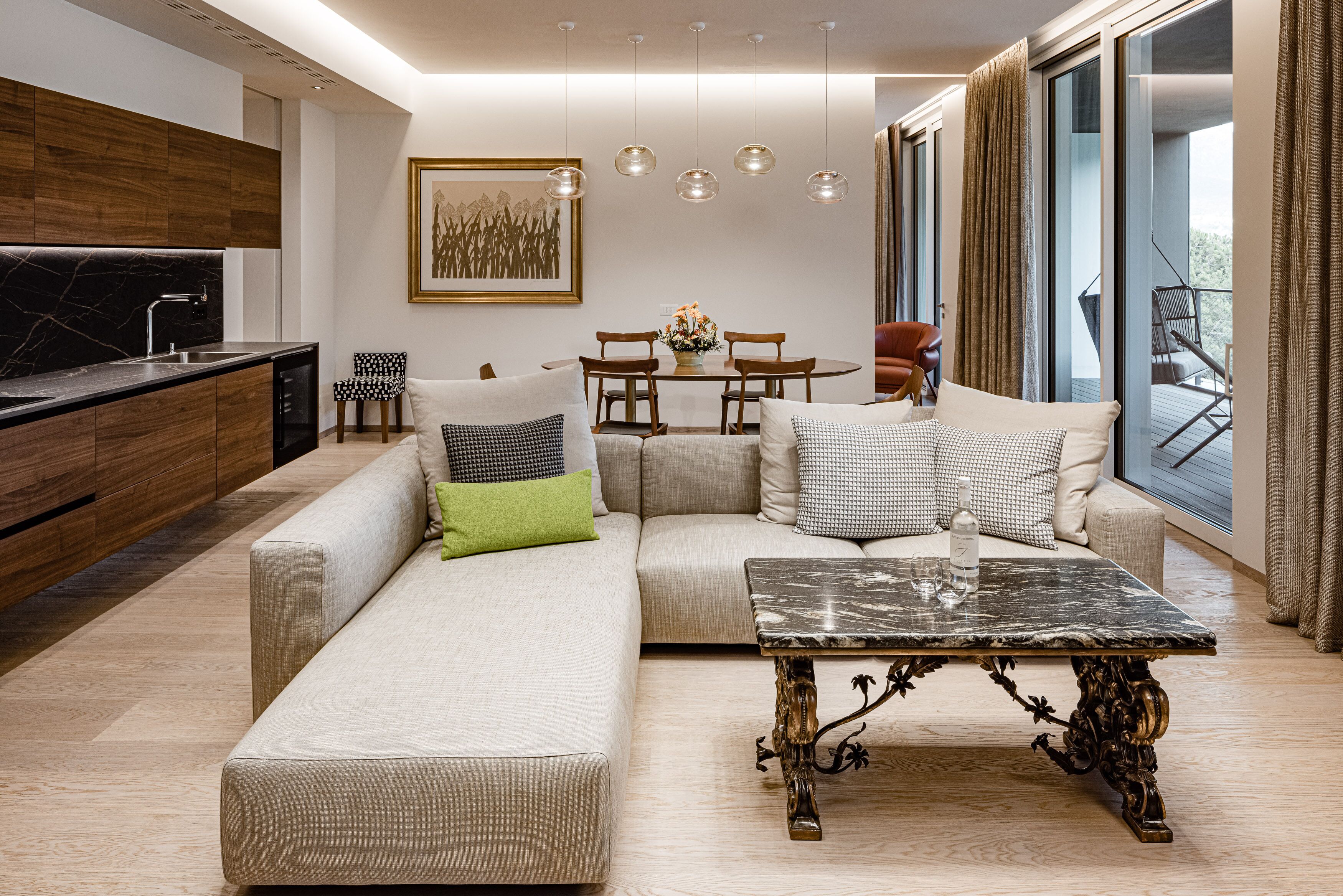A modern living room with a sofa, a coffee table, and a dining area.