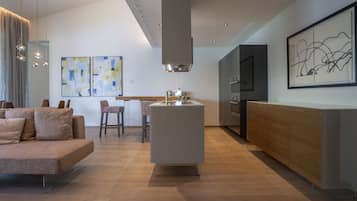 Een moderne keuken met een centraal eiland, een zithoek met een bank en kunstwerken aan de muren.
