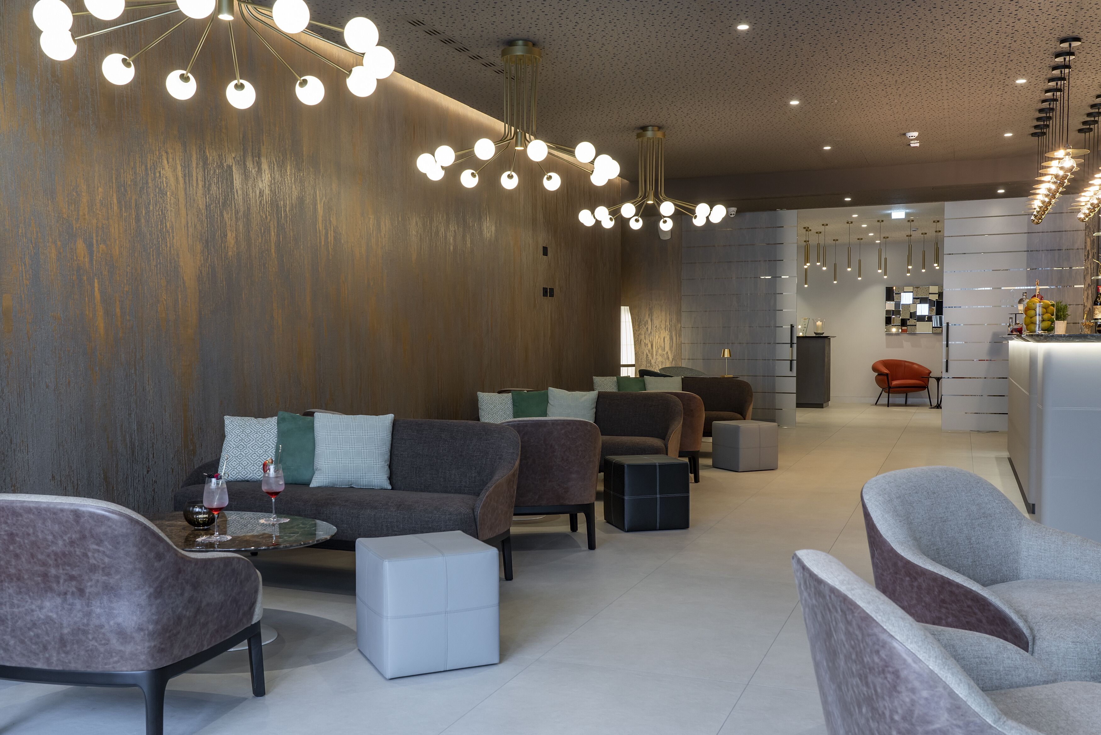 A modern interior with sofas, a coffee table, and a bar area.