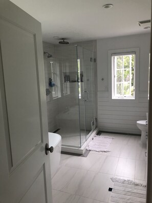 Een bad/douchecombinatie, een haardroger, handdoeken
