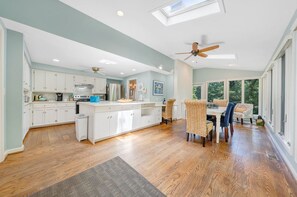 Enjoy meals in the kitchen with a central island, dining area, and large windows offering a view of the outdoors.