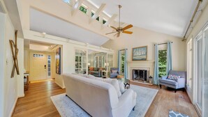 A spacious living room with a high ceiling, a fireplace, and a large window. - Lake Pleasant - Lakefront, Private Dock, Game room (Huddleston)