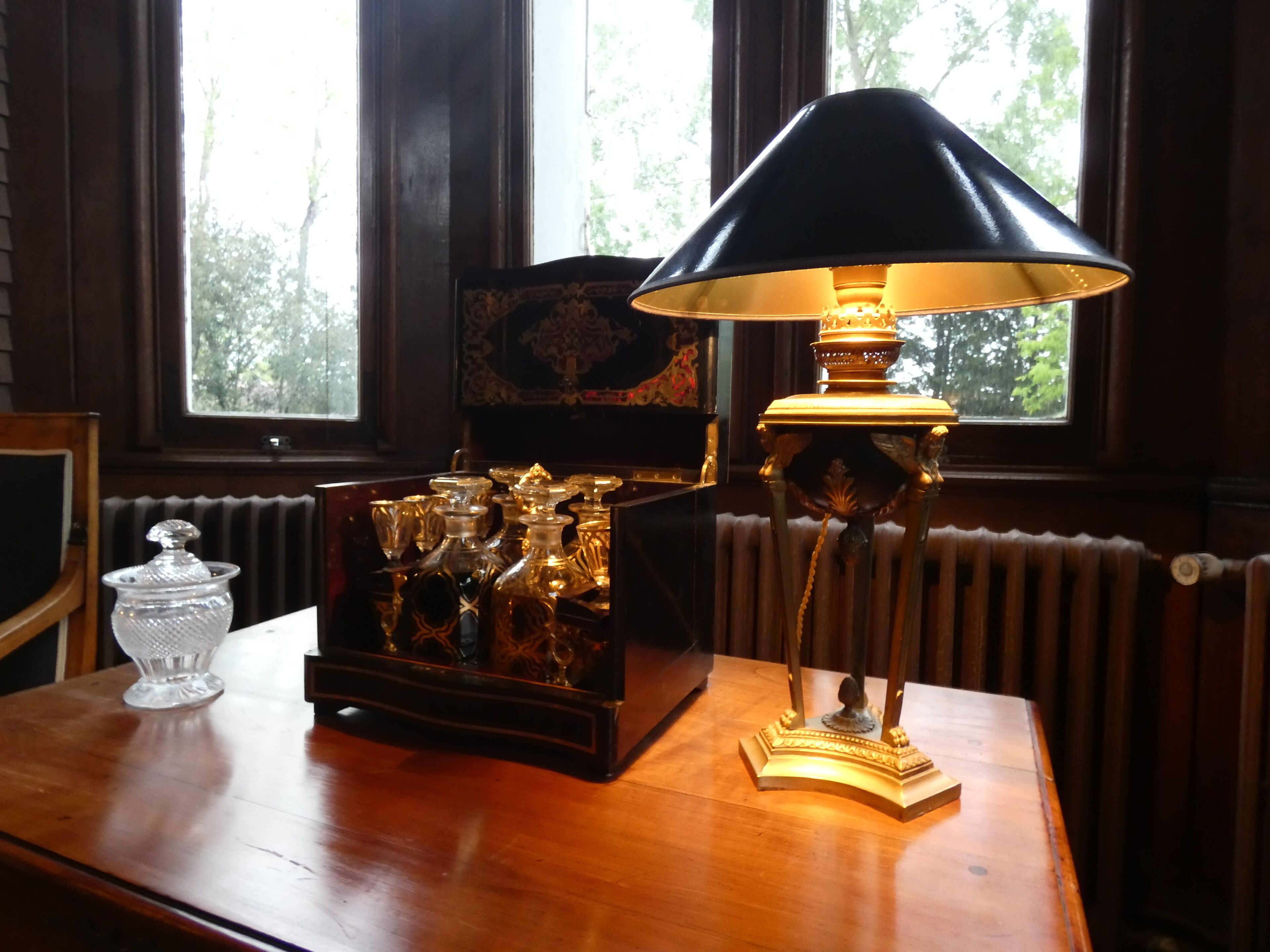 A table with a lamp, a decorative box, and a glass container.
