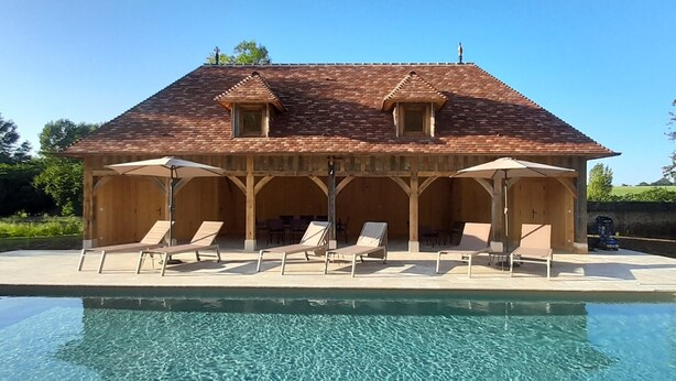 A pool with clear water, surrounded by a wooden deck with lounge chairs and umbrellas. - Chateau de Hieville (Saint-Pierre-en-Auge)