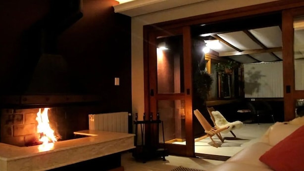 Une pièce chaleureuse avec une cheminée, une porte en bois et un canapé blanc.