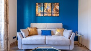 A modern living room with a white sofa, blue cushions, and a blue accent wall. - "Lumières", downtown Lyon, University of Medicine/Lyon 3, metro 200 m away, wifi (Lyon)