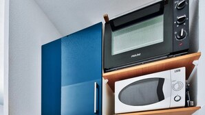 A compact kitchen with a microwave, stove, sink, and blue cabinets. - "Lumières", downtown Lyon, University of Medicine/Lyon 3, metro 200 m away, wifi (Lyon)