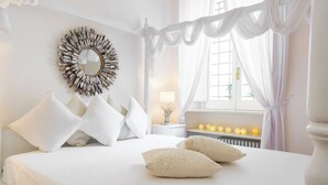 A bedroom with a canopy bed, a decorative mirror, and bedside lamps. - COLOSSEO HISTORIC APARTMENT (Roma)
