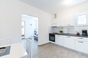 Enjoy a compact kitchen with a sleek stove, dining area, and cozy living space.