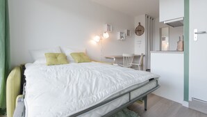 Ein modernes Schlafzimmer mit Bett, Nachttisch und Schreibtisch mit Stuhl.
