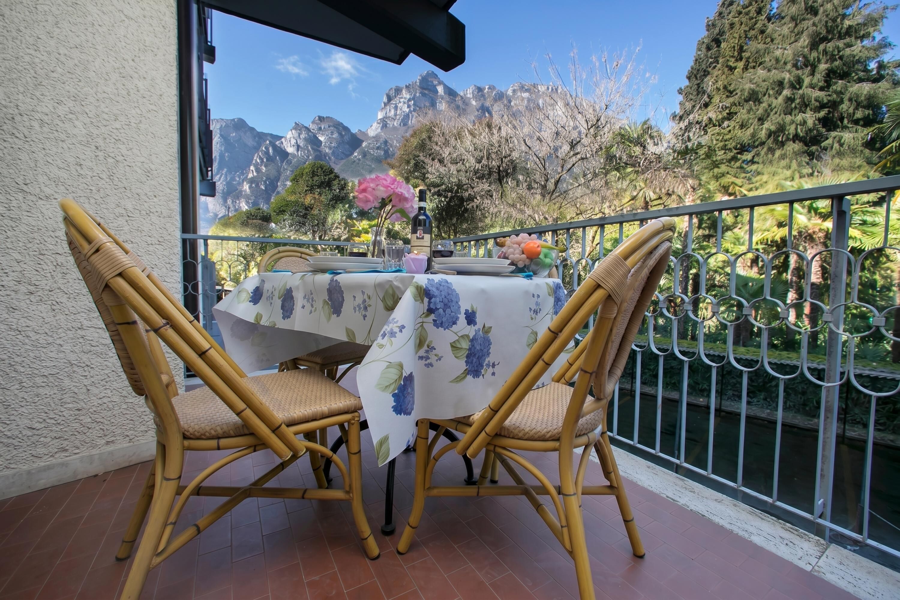 Ein Balkon mit Tisch für zwei Personen, mit Blick auf eine gebirgige Landschaft.