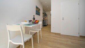 En matplats med ett bord dukat för två personer, en fruktskål och en flaska vin.