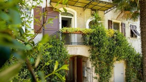 A building with a balcony, a door, and a window. - Casa Alla Grotta (Arco)
