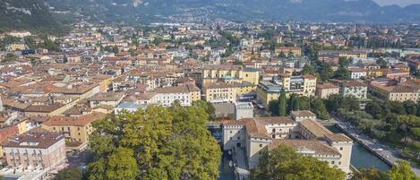 A panoramic view of a historic town with a river, buildings, and mountains in the background.