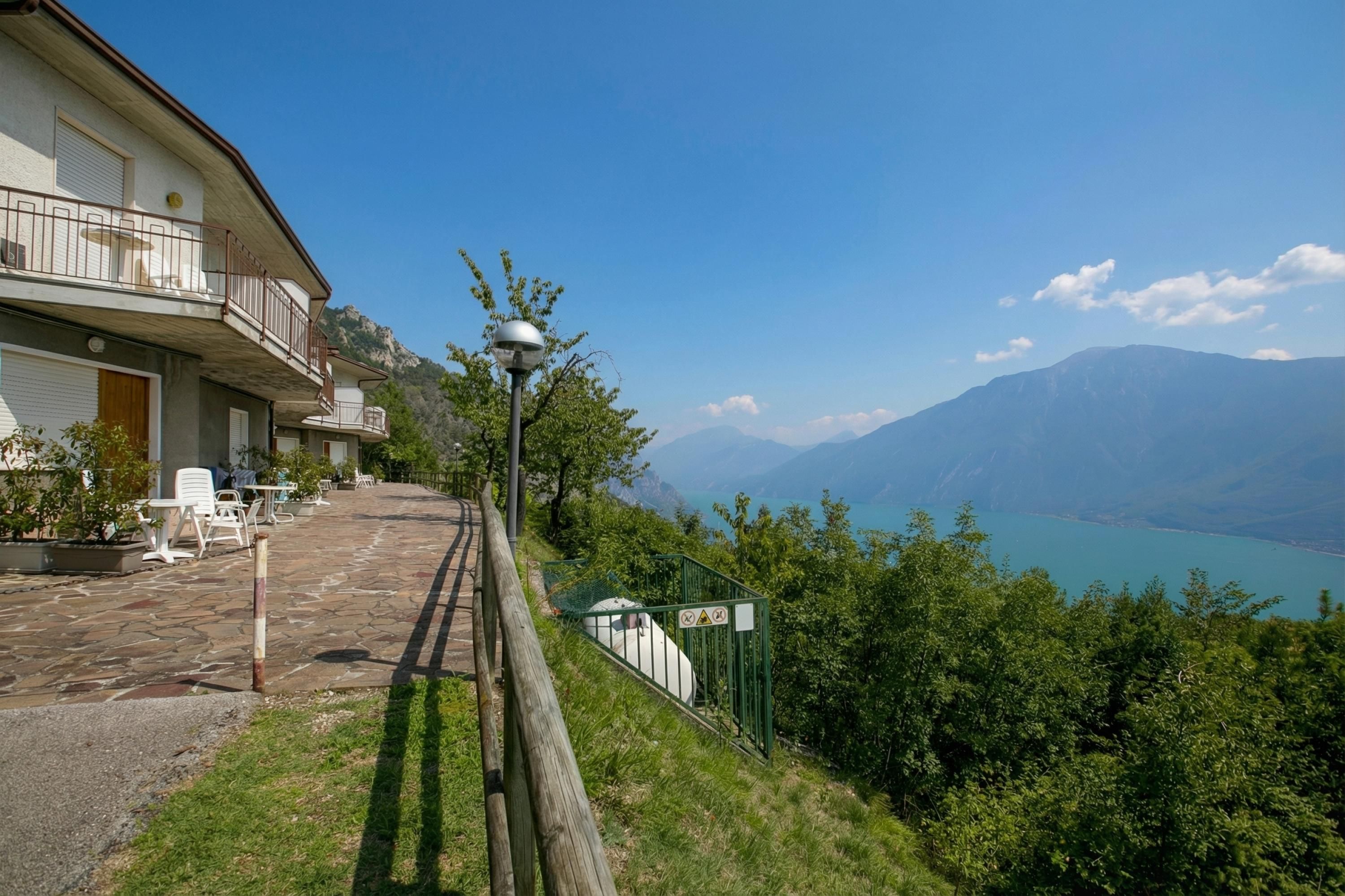 Ein Gebäude mit Außenbereich, einer Treppe und Blick auf Berge und einen See.