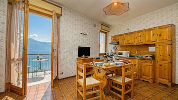 A kitchen with wooden cabinets and a dining area with a table and chairs.