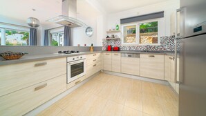 A modern kitchen with a gas stove, oven, and stainless steel refrigerator.
